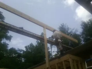 Carpenter setting a ridge beam over a new addition frame — Ice Dam Removal by Roofing Brothers in Millen
