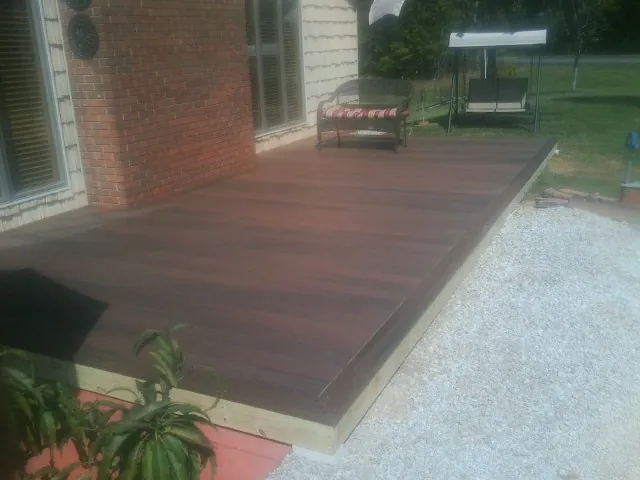 Freshly stained wood deck built against a brick home in Millen