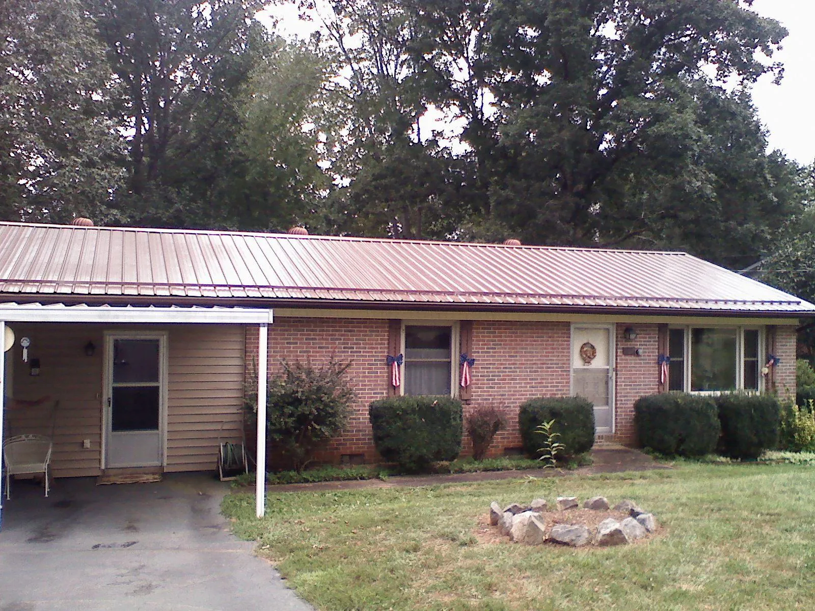 Bronze metal roof and carport on a brick ranch home — Roof Repair work by our crew in Millen
